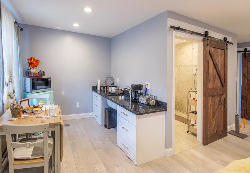 Image inside a studio aparment with lower cabinets, sliding barn doors and a roll in shower